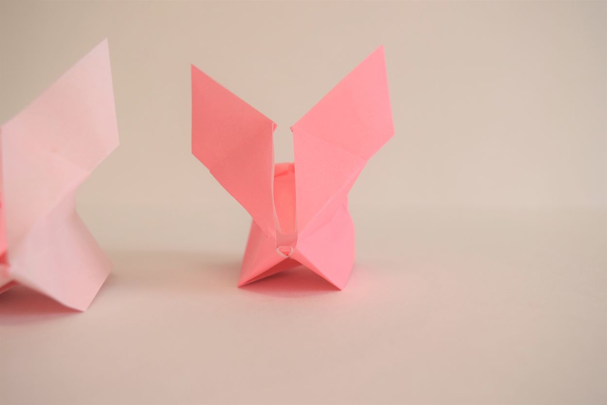 1 pink origami bunny looking right at the camera