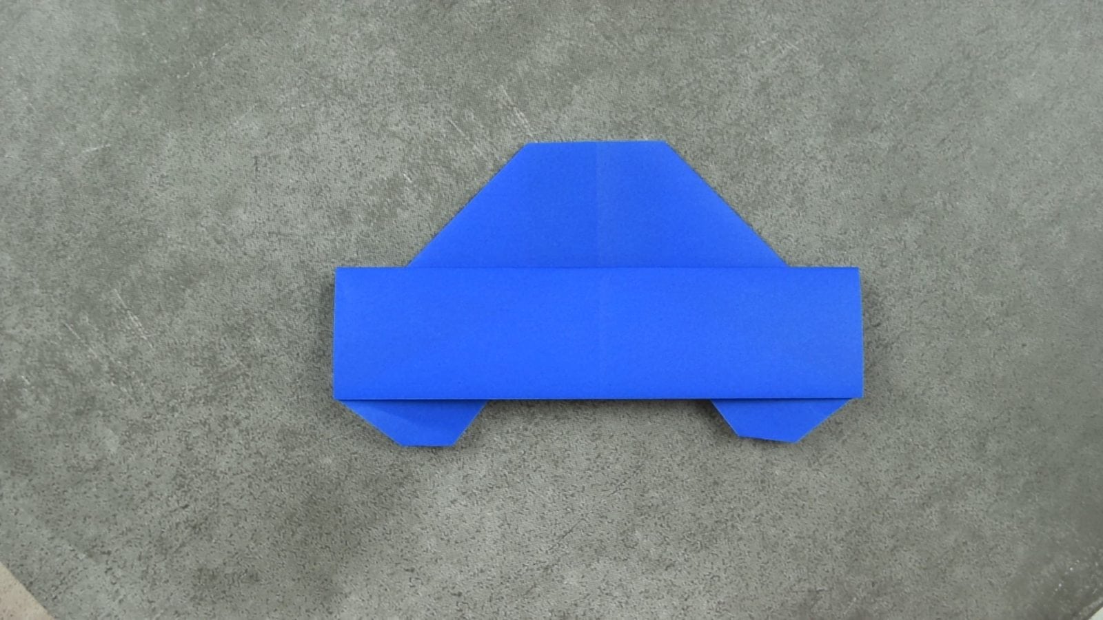 Blue paper Origami Car on gray background folded for FaveMom