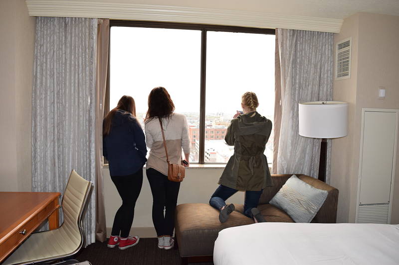 3 teen girls enjoying the view from a hotel dureing a birthday hotel staycation