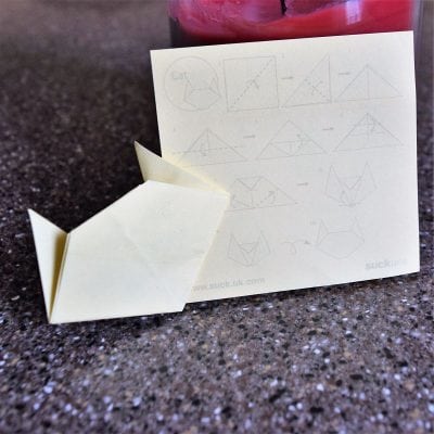 origami cat from yellow sticky note on black background
